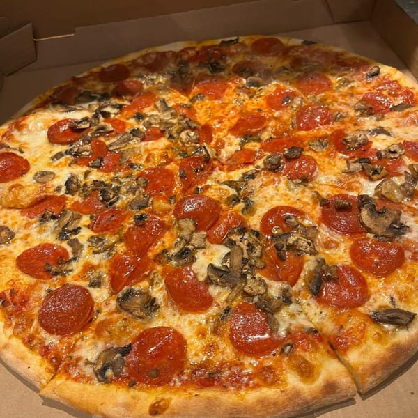 A whole pepperoni and mushroom pizza from Enzo's Pizzeria, with a slice removed, in a cardboard box.