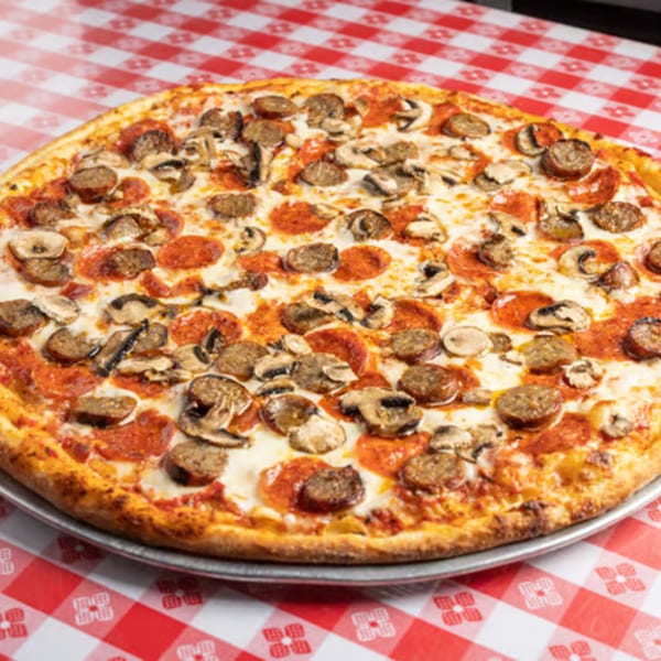 Enzo's Pizzeria pizza with pepperoni, sausage, and mushrooms on a red and white checkered tablecloth.